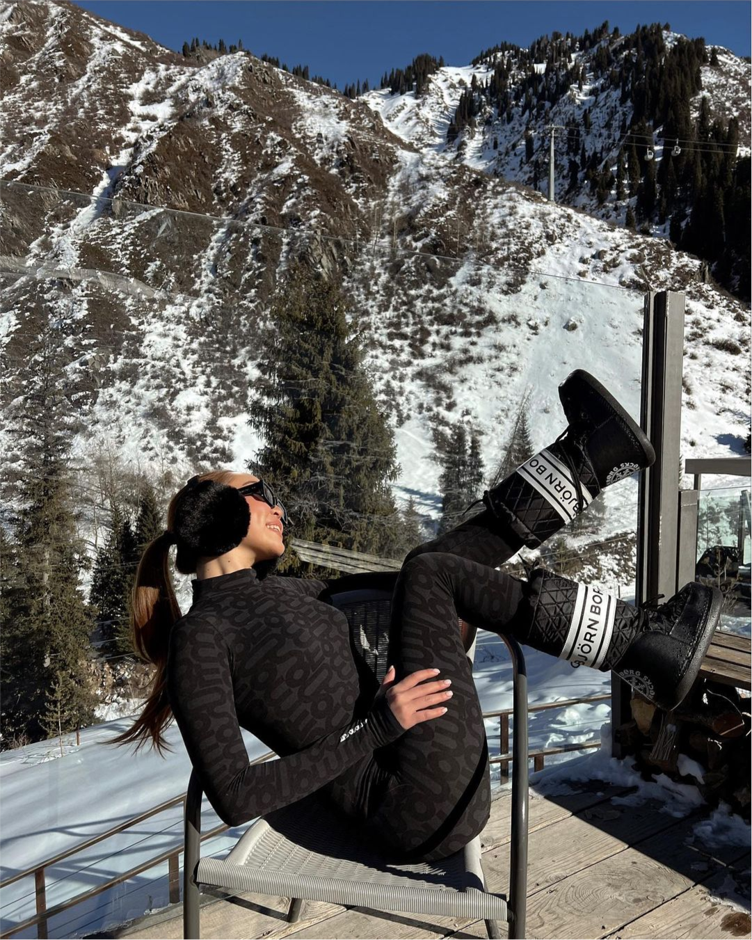 Woman in black Monosuit in snowy mountains