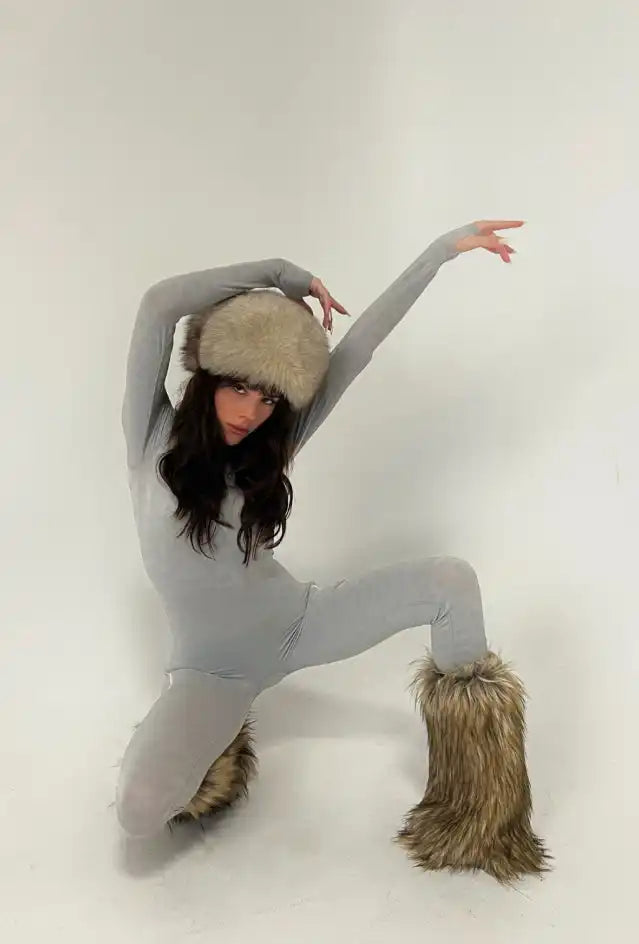 Dancer in a gray bodysuit and furry boots striking a dramatic pose.