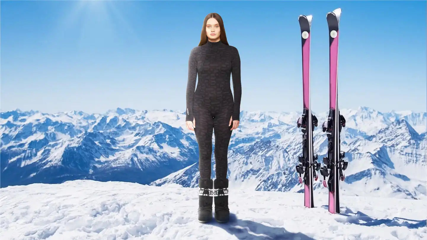 Pink and black skis with bindings standing upright in snow.