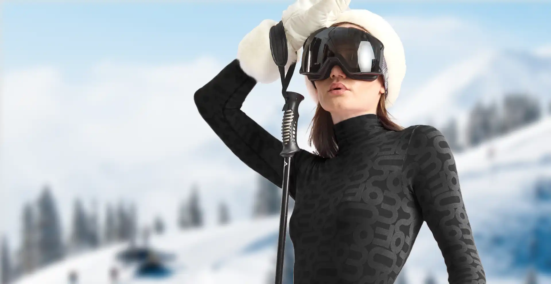 Skier wearing a black winter jacket and ski goggles against snowy slopes.